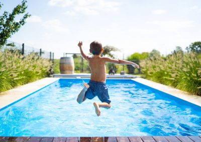a little boy jumping in the swimming pool